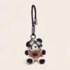 Plush panda keychain wearing aviator goggles and tan heart sweater with black rope strap
