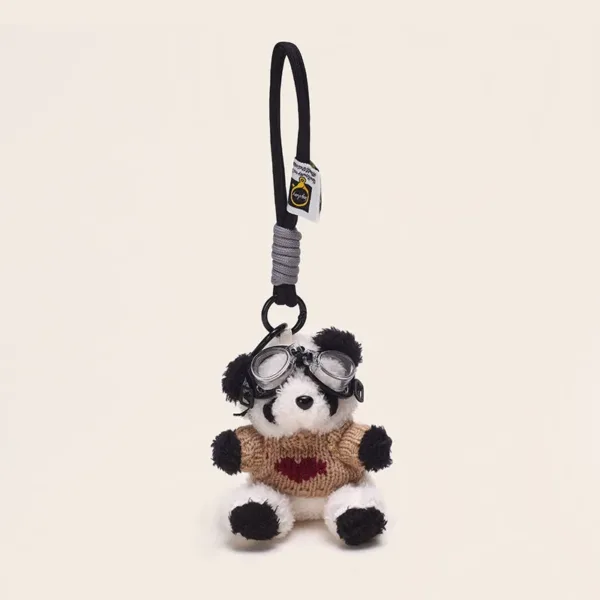 Plush panda keychain wearing aviator goggles and tan heart sweater with black rope strap