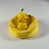 Pokémon Pikachu Ornament (1) Pikachu figurine sitting contentedly in a yellow bean bag cushion
