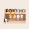 Cute animal keychains and figurines on wooden display shelf including panda, fox, duck, and bear characters