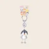 Cute penguin keychain with gray clasp and dangling rope legs on colorful animal character backing card