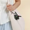 Child holding pink tote bag with Toothless dragon keychain from How to Train Your Dragon