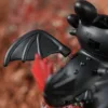 Black Toothless dragon toy with bat-like wings and OFF/ON switch on back