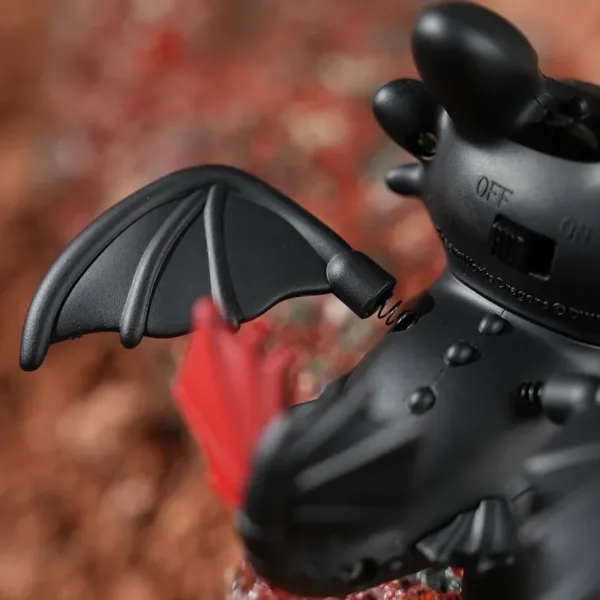 Black Toothless dragon toy with bat-like wings and OFF/ON switch on back