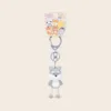 Cute gray wolf keychain charm with dangling legs on colorful animal-themed retail card