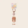 Cute brown bear keychain with dangling rope legs and colorful animal character backing card