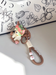 Devon Cat keychain with cute cat figure wearing dinosaur costume and paw print beads