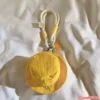Yellow Corduroy Bucket Hat Keychain Charm with Rope Strap Yellow corduroy bucket hat keychain with white rope strap and CRYLER brand tag on white fabric background