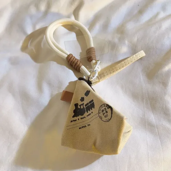 Beige canvas triangle coin pouch with train print and Chicago postmark stamp design