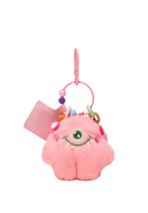 Pink fluffy one-eyed monster plush keychain with green eye, white fangs, colorful beads, and pink clip attachment