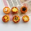 Six miniature Portuguese egg tart charms with cute decorations like cat paw prints and flowers