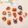 Colorful food-themed refrigerator magnets featuring bread, pastries, lobster, and breakfast items