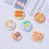 Miniature resin food charms featuring eggs, pizza, dumplings, cookies, and churros on tiny plates