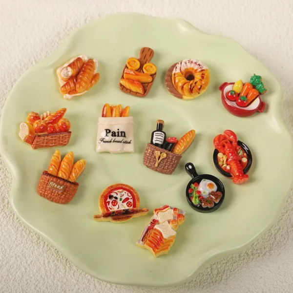 Miniature food magnets featuring bread baskets, pastries, and cooking pans on green plate