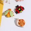 Three colorful ceramic garden creature figurines - bee, ladybug, and snail on white surface