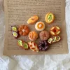 Miniature clay pastries and bread arranged on vintage entomology book page