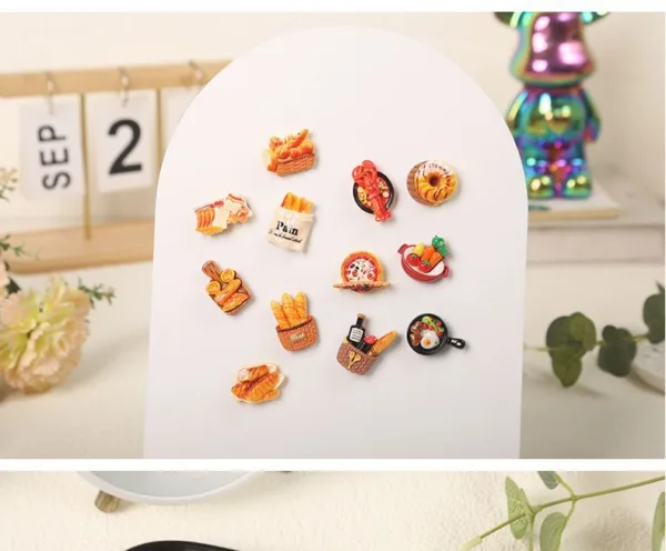 Food-themed refrigerator magnets featuring bread baskets, pastries, and breakfast items on white display board