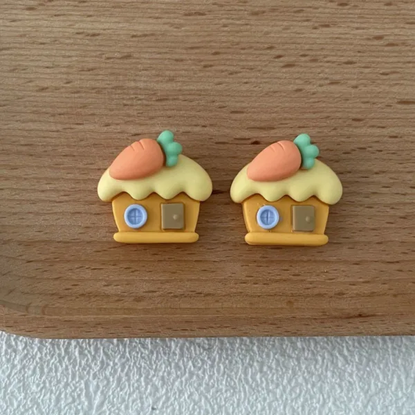 Cute carrot house earrings in orange and yellow on wooden surface