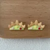 Handmade polymer clay earrings shaped like garden fences with green grass and colorful flowers