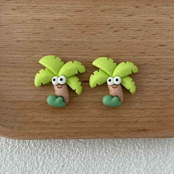 Cute polymer clay palm tree stud earrings with googly eyes on wooden surface