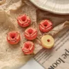 Miniature strawberry donuts with cream filling on crinkled brown paper and newspaper