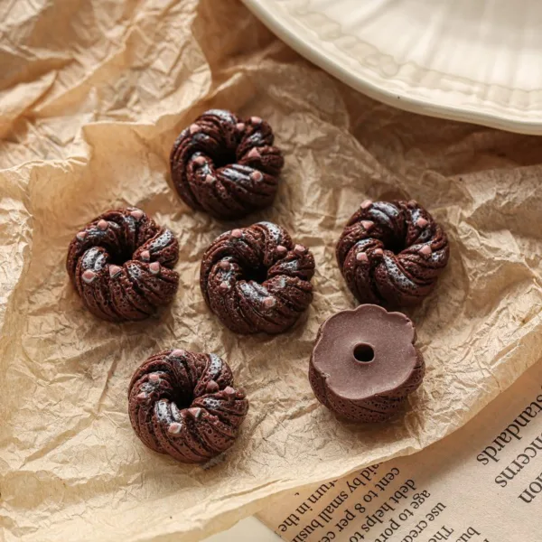 Mini chocolate bundt cakes with pink chips on crinkled brown parchment paper