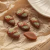 Miniature clay bread loaves with green pistachio filling on crinkled brown paper